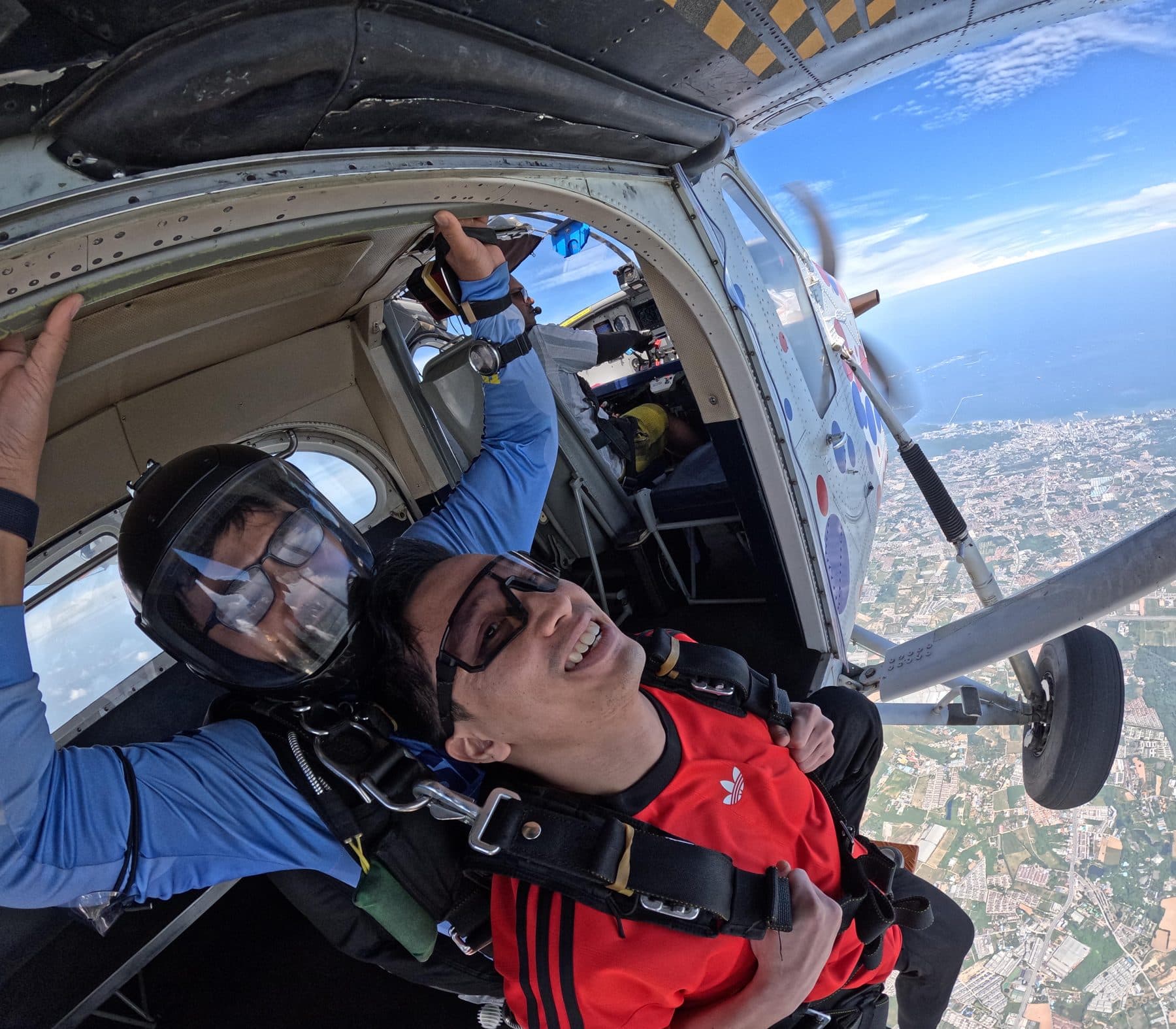 Passenger grinning at the open aircraft door with the instructor behind him