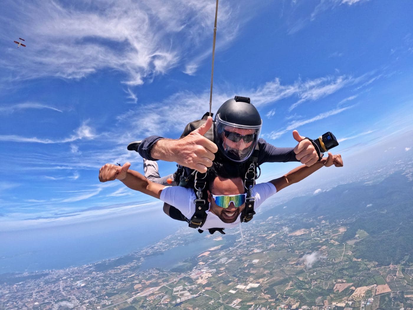 Tandem pair in freefall with the Pattaya coastline behind them